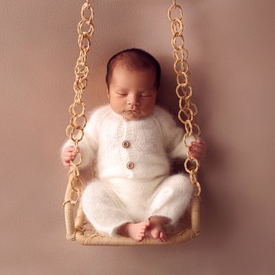 baby on swing in newborn photo studio Poway, CA