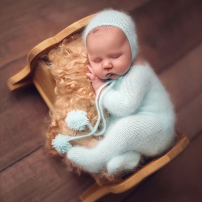 baby boy in aqua outfit on little bed