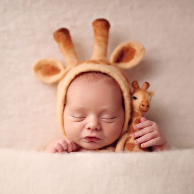 Baby with giraffe hat and toy