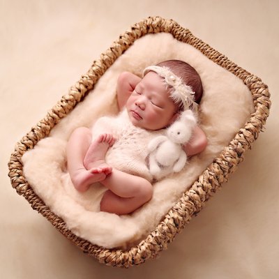 Newborn photography San Diego baby in a basket with toy