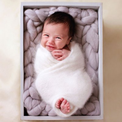 baby wrapped in gray box