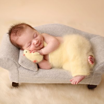 newborn boy in fluffy yellow outfit 