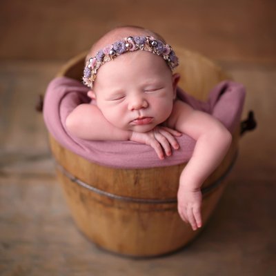 Baby in bucket with mauve headband
