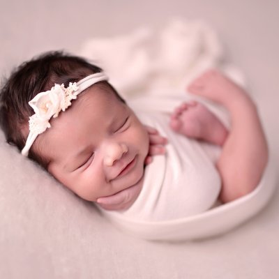 Smiling baby girl wrapped in cream