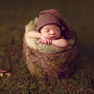 baby boy on moss background with mushrooms