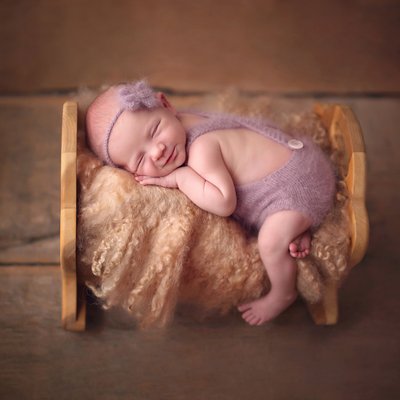 baby girl smiling in bed, La Jolla newborn photos