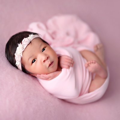 Older newborn focus on eye contact during newborn photography session in San Diego