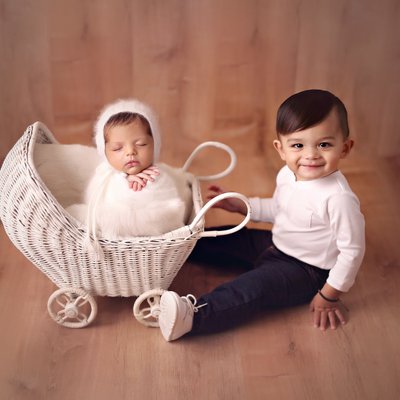 San Diego newborn photographer with baby brother sitting by stroller