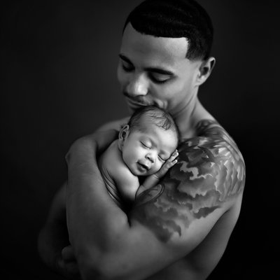 happy father with tattoo holding baby