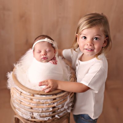 Little boy holding newborn girl