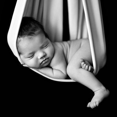 Black and white picture of hanging baby