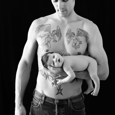 Father with tattoo holding baby