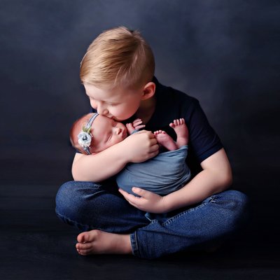 brother hugging newborn sister