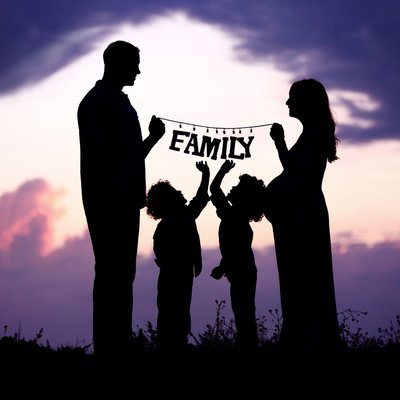 holding family sign on sunset