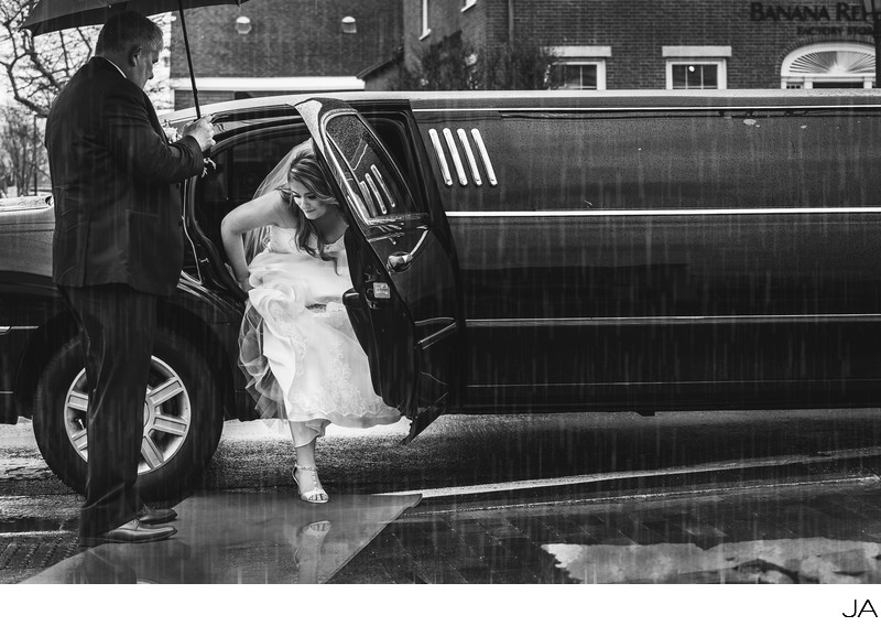 Bride arriving by limo in the rain