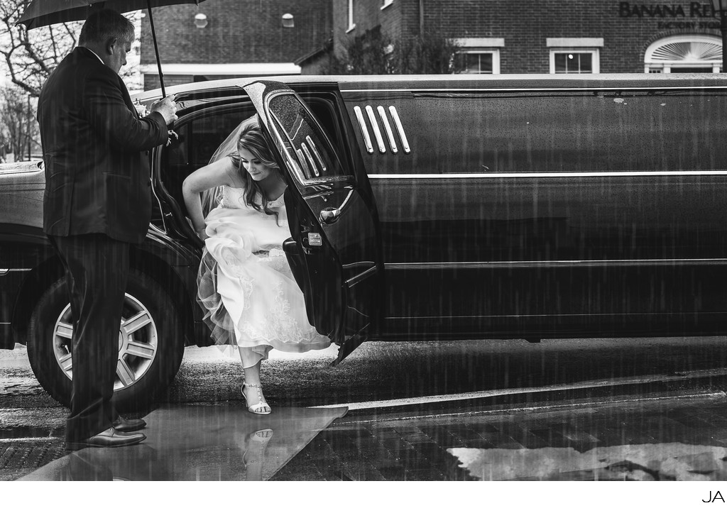 Bride arriving by limo in the rain