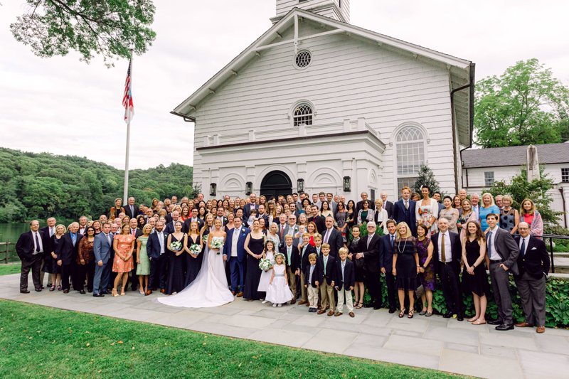 A large traditional wedding portrait outside of a church.