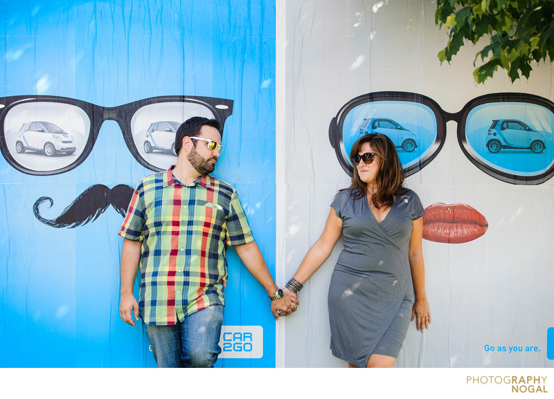 Couple Holding Hands Beside a Sunglasses Ad