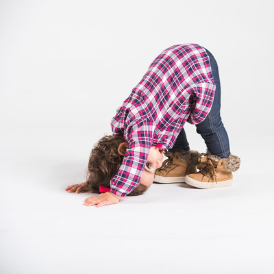 A kid doing the downward dog in the studio
