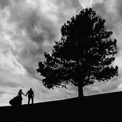 Couple Walking Up Hill Next To A Tree