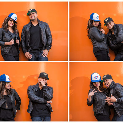 Couple lets loose in sports hats against orange wall
