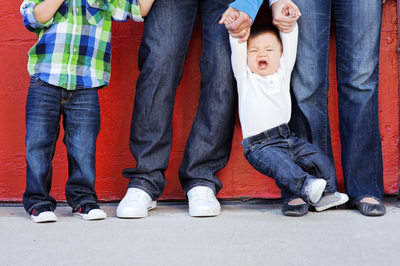 baby boy crying while family stands