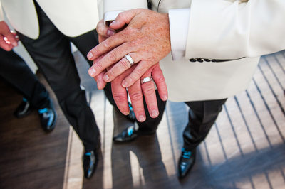 Gay Couple Showing Wedding Rings To Camera