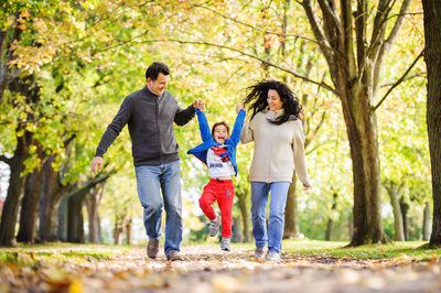 mom dad and son running through the park