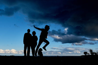 Silhouette of a family and kid jumping