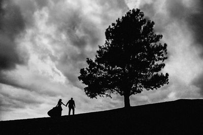 Couple Walking Up Hill Next To A Tree