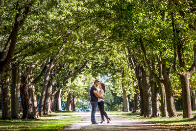 Toronto couple embrace under tree arch