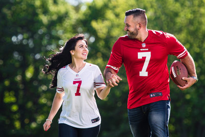 Football fan couple running with football