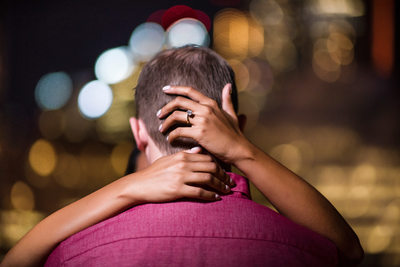 A Hand Around The Head Showing Off Engagement Ring