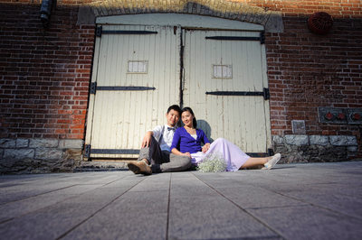 couple sits against white gate St Lawrence Market