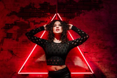 model against red neon light triangle