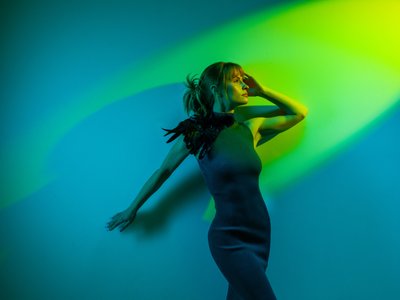 girl facing green light on blue background