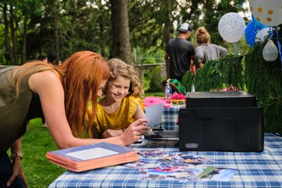 Mom and daughter printing a photo at family reunion