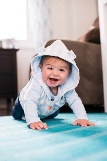 baby boy crawling on floor and smiling