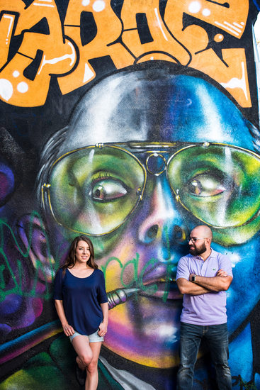 Couple against wall at Graffiti Alley in Toronto