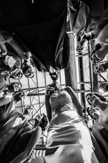 Bride and Groom Kissing While Wedding Party Watches