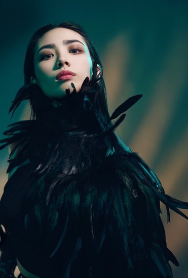 editorial stylized portrait of woman wearing feathers