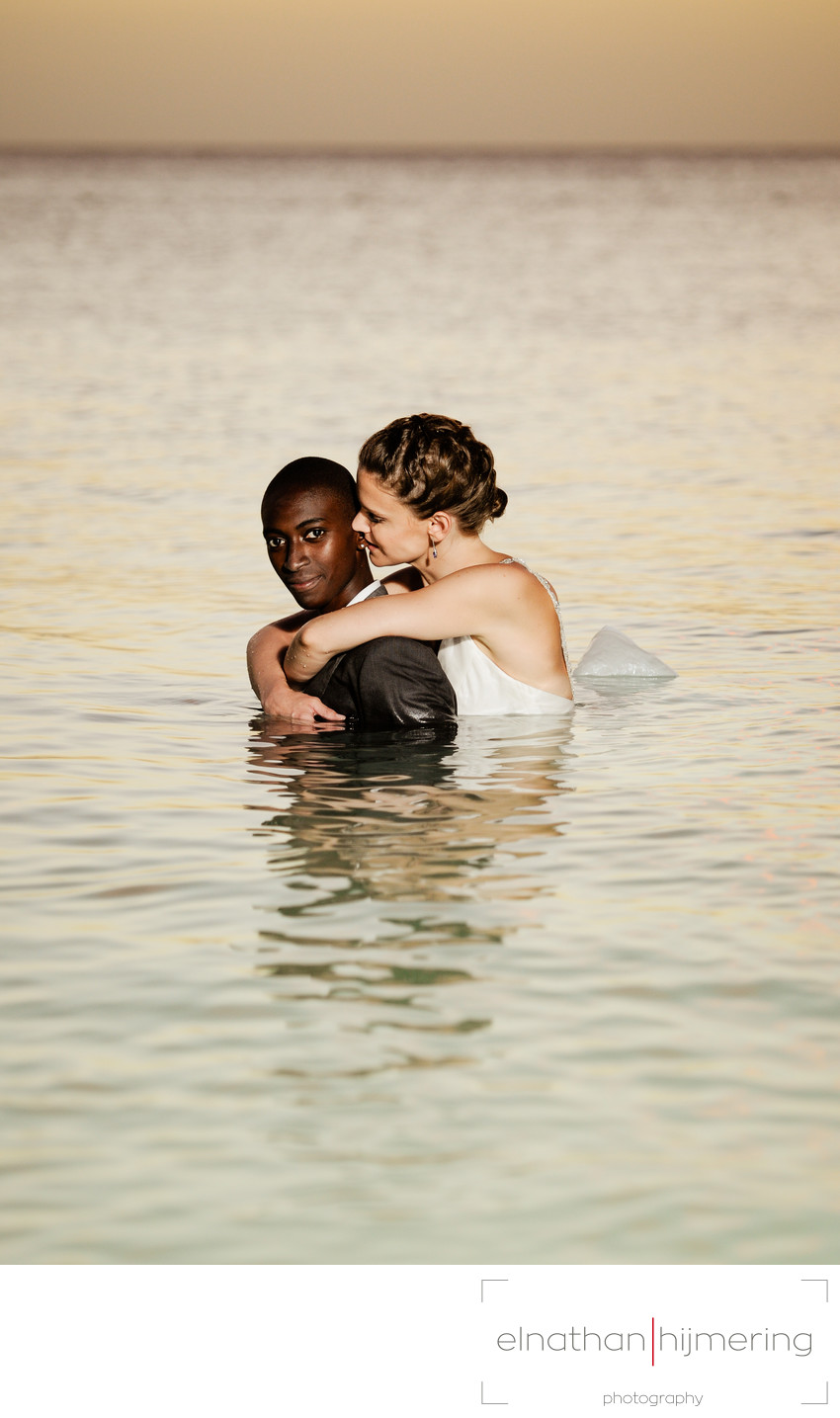 Same Sex wedding couple in water looking