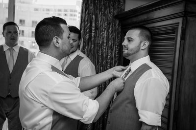 best man fixing groom tie
