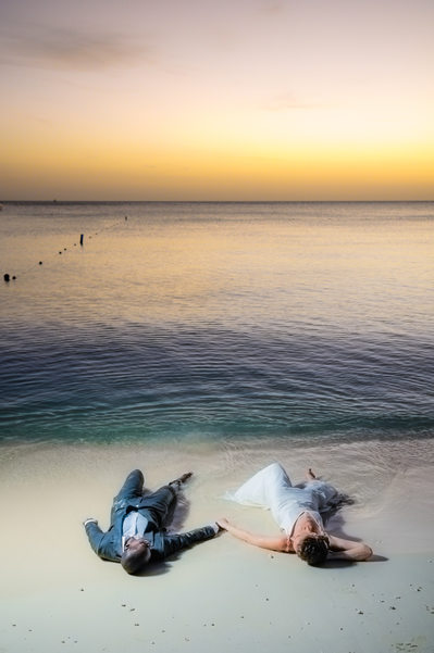 LGBTQ couple laying on beach