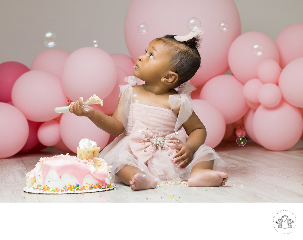 cake smash session with pink balloons