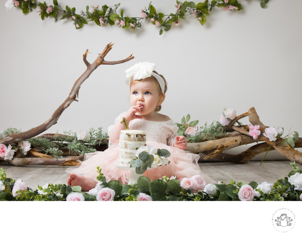 cake smash photo session with green and tree branches