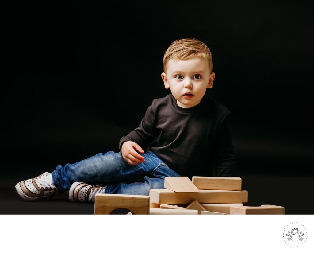 toddler boy portrait black backdrop