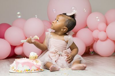 cake smash session with pink balloons