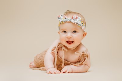 Happy baby wearing headband portrait session