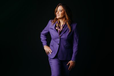 business woman in purple suit black backdrop